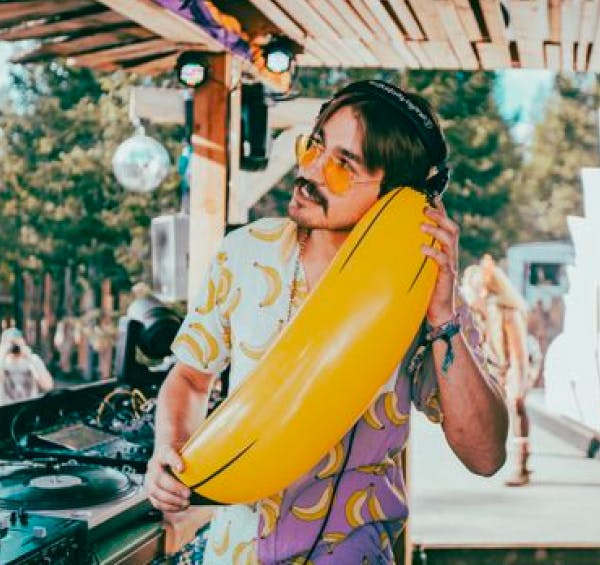 DJ Benanas holding a giant inflatable banana as a phone